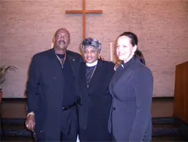 People posing for camera with cross background