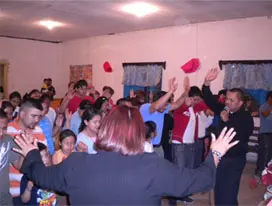 People raising thier hands and a lady managing them