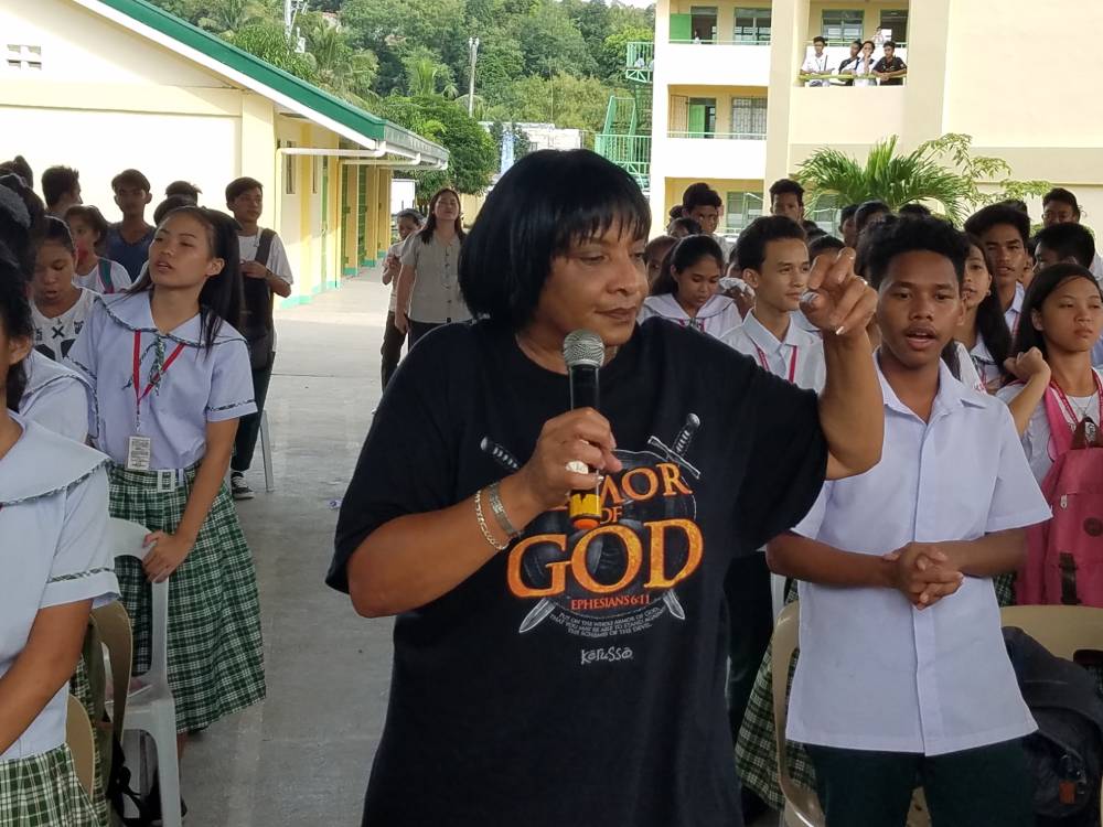 Women with mic in hand having talk with students